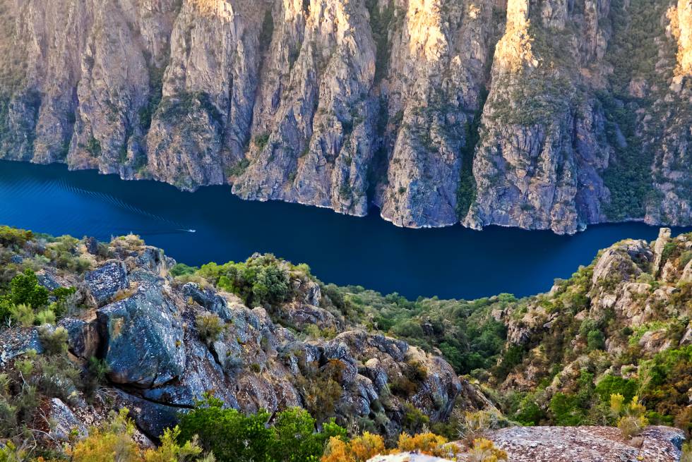 Una zigzagueante hendidura recorre el paisaje de la Ribeira Sacra. El río Sil recorre en su último tramo, antes de unirse al Miño, un profundo cañón en cuyas orillas los bosques de robles, abedules y castaños rozan el agua, y las terrazas de viñedos trepan por las laderas. Varios cruceros ofrecen travesías por el desfiladero desde los embarcaderos de Santo Estevo (Nogueira de Ramuín), Abeleda (A Teixeira), Doade (Sober) y Os Chancís (Sober).  turismo.ribeirasacra.org 